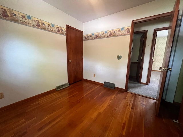 spare room with wood finished floors and baseboards