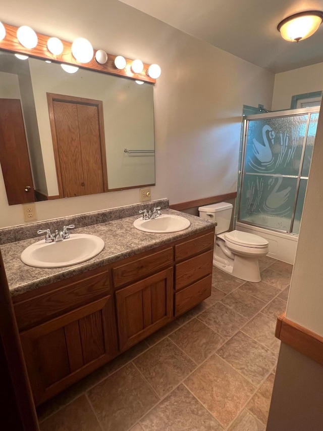 full bathroom with toilet, double vanity, and combined bath / shower with glass door