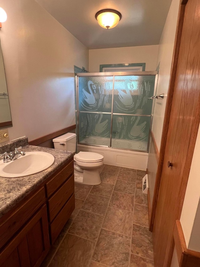 full bath with toilet, bath / shower combo with glass door, and vanity
