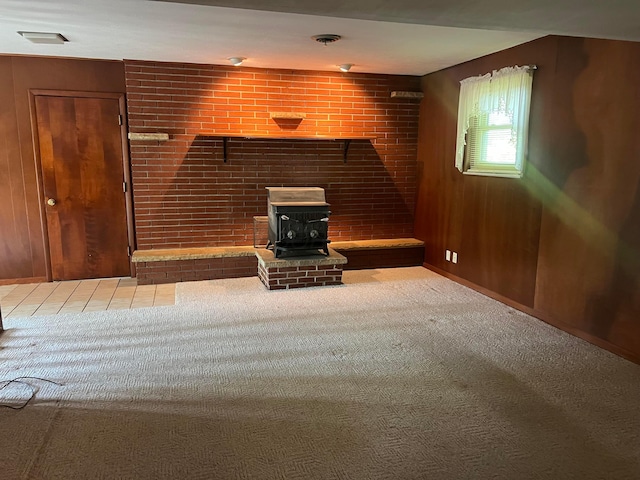 unfurnished living room featuring a wood stove and carpet