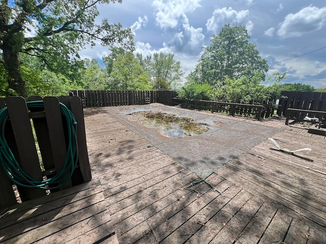 wooden deck with a fenced backyard
