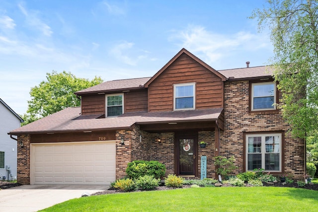view of front facade featuring a front yard, concrete driveway, brick siding, an attached garage, and a shingled roof
