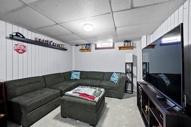 living area featuring a drop ceiling and carpet flooring