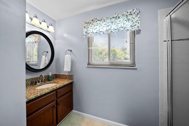 bathroom featuring baseboards, vanity, tile patterned flooring, and a shower with shower door