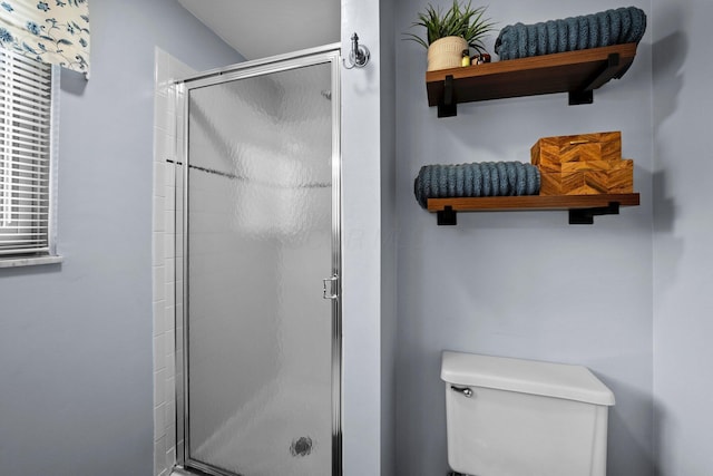full bath featuring a shower stall and toilet
