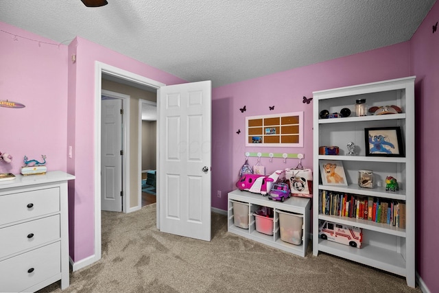 playroom featuring light colored carpet and a textured ceiling