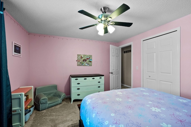 carpeted bedroom featuring a closet, a ceiling fan, and a textured ceiling
