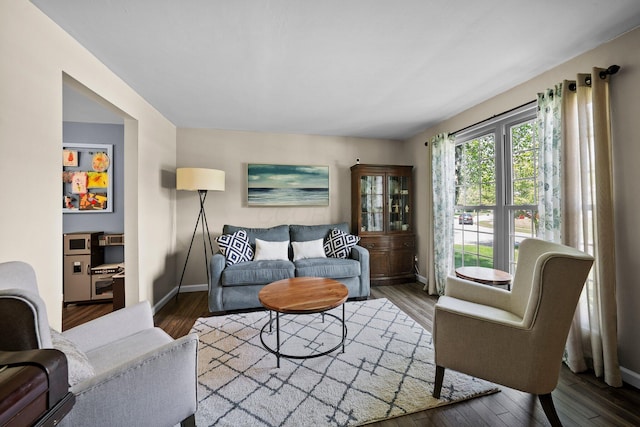 living area with baseboards and wood finished floors