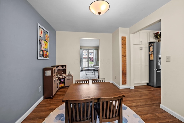 dining room featuring dark wood finished floors and baseboards