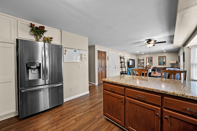 kitchen with stainless steel fridge, ceiling fan, dark wood-style flooring, baseboards, and light stone countertops