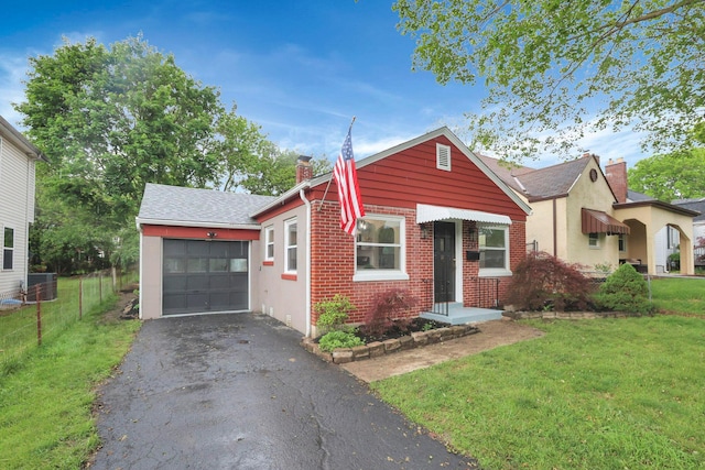 234 Rosslyn Ave, Columbus, OH 43214 - view of front of property with a chimney, asphalt driveway, a garage, brick siding, and cooling unit