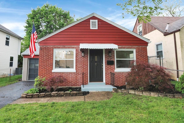 234 Rosslyn Ave, Columbus, OH 43214 - bungalow-style home with brick siding, asphalt driveway, and cooling unit