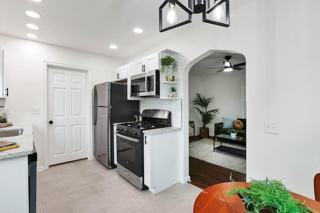 234 Rosslyn Ave, Columbus, OH 43214 - kitchen with appliances with stainless steel finishes, white cabinets, ceiling fan, arched walkways, and recessed lighting