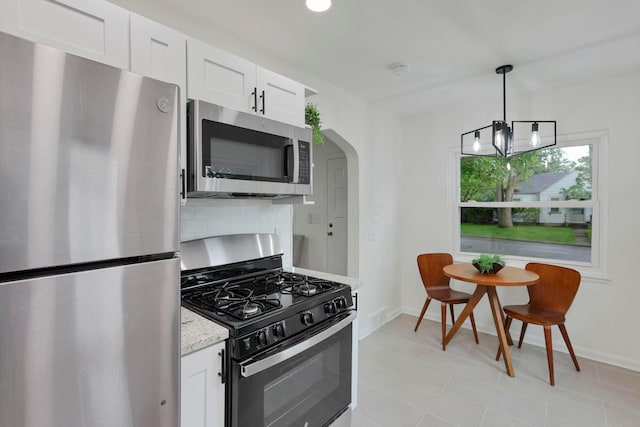 234 Rosslyn Ave, Columbus, OH 43214 - kitchen featuring appliances with stainless steel finishes, baseboards, arched walkways, and backsplash