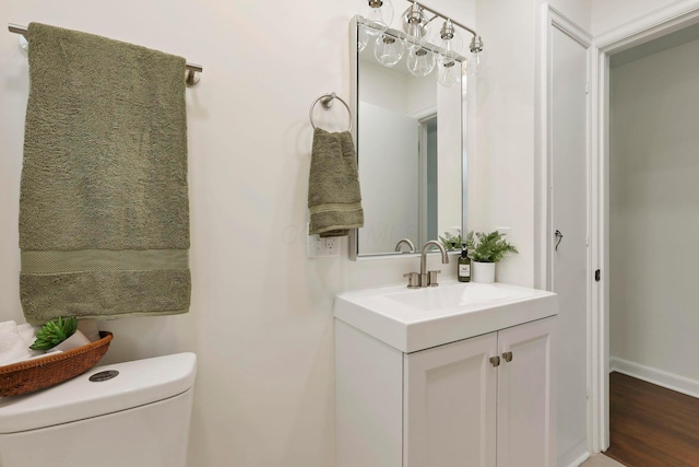 234 Rosslyn Ave, Columbus, OH 43214 - half bathroom with toilet, vanity, baseboards, and wood finished floors