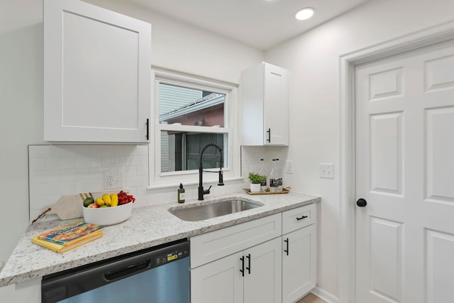234 Rosslyn Ave, Columbus, OH 43214 - kitchen featuring a sink, stainless steel dishwasher, decorative backsplash, white cabinetry, and light stone counters