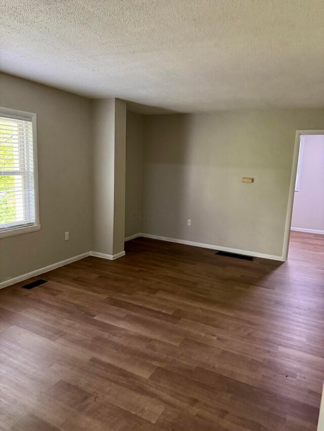 9966 Larimer Rd, Logan, OH 43138 - spare room featuring dark wood-type flooring, baseboards, and a textured ceiling