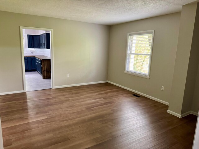 9966 Larimer Rd, Logan, OH 43138 - unfurnished room with wood finished floors, baseboards, and a textured ceiling