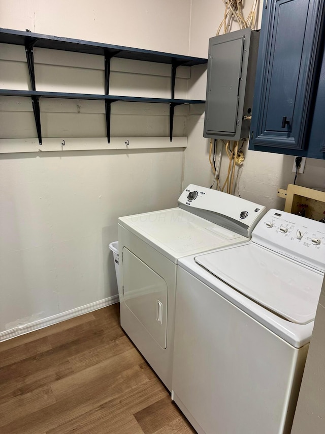 9966 Larimer Rd, Logan, OH 43138 - washroom with electric panel, washer and clothes dryer, wood finished floors, baseboards, and cabinet space