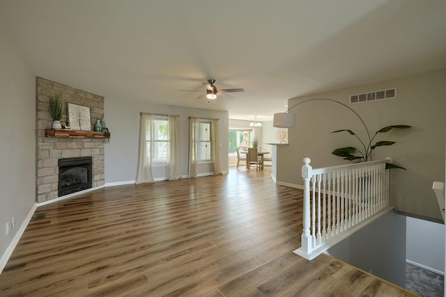 1899 Lamb Rd NW, Carroll, OH 43112 - unfurnished living room with a ceiling fan, wood finished floors, a stone fireplace, and baseboards