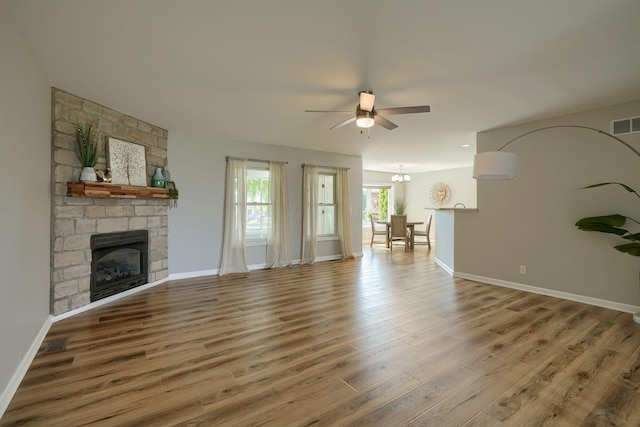 1899 Lamb Rd NW, Carroll, OH 43112 - unfurnished living room with a ceiling fan, wood finished floors, baseboards, a fireplace, and a chandelier
