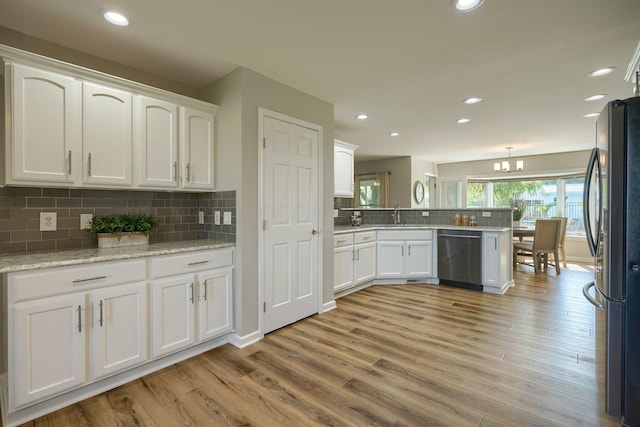 1899 Lamb Rd NW, Carroll, OH 43112 - kitchen with stainless steel appliances, a peninsula, white cabinets, light wood-style floors, and decorative backsplash
