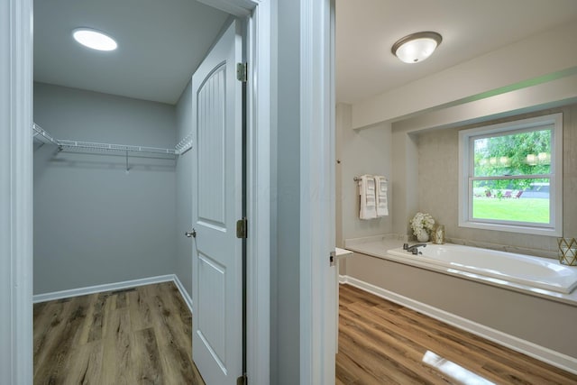 1899 Lamb Rd NW, Carroll, OH 43112 - bathroom with a bath, a spacious closet, wood finished floors, and baseboards