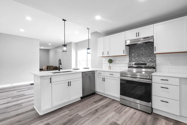 527 E Welch Ave, Columbus, OH 43207 - kitchen featuring stainless steel appliances, under cabinet range hood, a peninsula, a sink, and white cabinetry