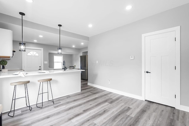 527 E Welch Ave, Columbus, OH 43207 - kitchen featuring freestanding refrigerator, a peninsula, light wood-style floors, light countertops, and recessed lighting