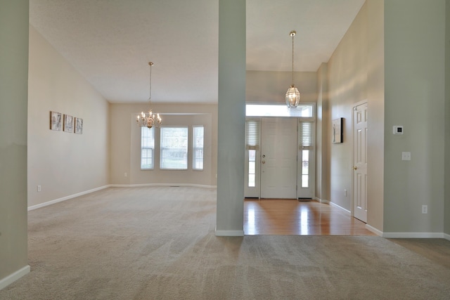 5988 Carnegie Cove Ct, Columbus, OH 43213 - carpeted entrance foyer with baseboards, a chandelier, and a towering ceiling