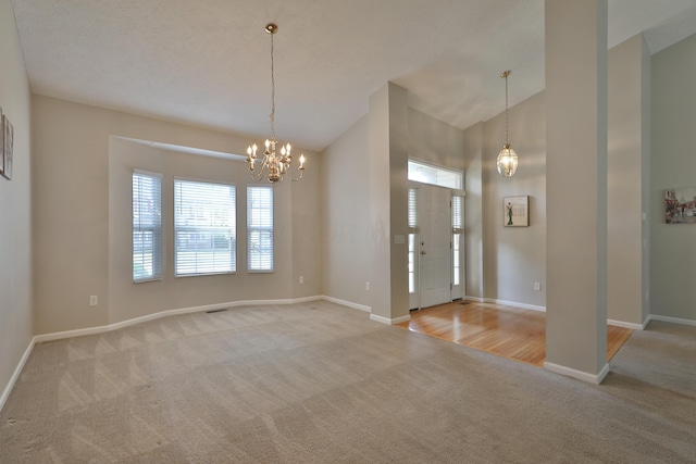 5988 Carnegie Cove Ct, Columbus, OH 43213 - foyer with carpet, a chandelier, baseboards, and high vaulted ceiling