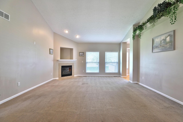 5988 Carnegie Cove Ct, Columbus, OH 43213 - unfurnished living room featuring vaulted ceiling, light carpet, baseboards, a tiled fireplace, and a textured ceiling