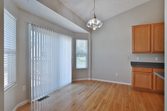 5988 Carnegie Cove Ct, Columbus, OH 43213 - unfurnished dining area with a chandelier, light wood-style floors, and baseboards