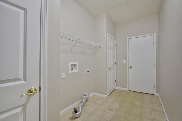 5988 Carnegie Cove Ct, Columbus, OH 43213 - washroom featuring electric dryer hookup, washer hookup, a textured ceiling, and baseboards