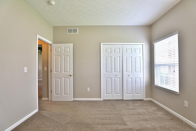 5988 Carnegie Cove Ct, Columbus, OH 43213 - unfurnished bedroom featuring carpet floors, a closet, baseboards, and a textured ceiling