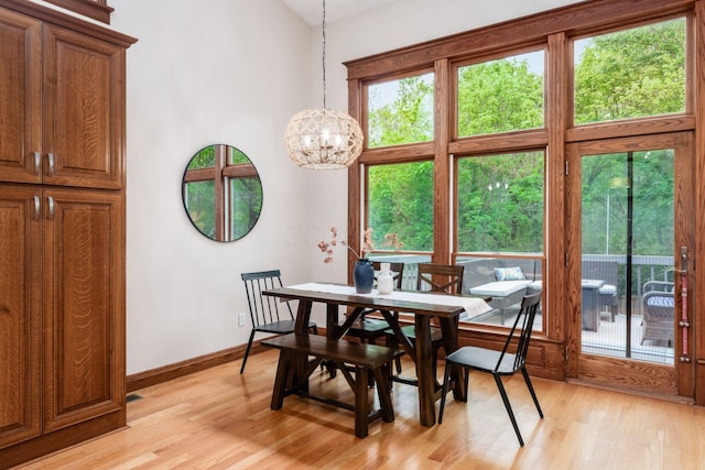 dining space featuring a chandelier, light wood-style flooring, and healthy amount of natural light