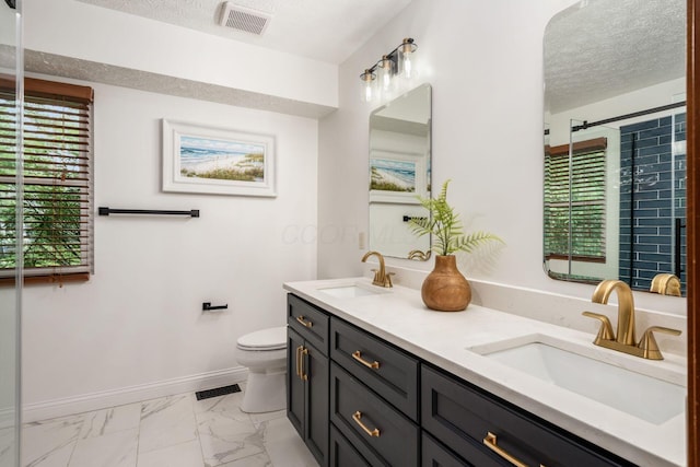 full bath with a textured ceiling, marble finish flooring, toilet, double vanity, and baseboards