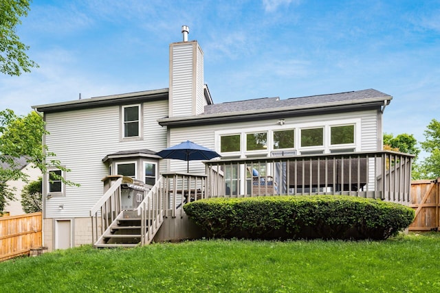 rear view of house featuring a wooden deck and a chimney