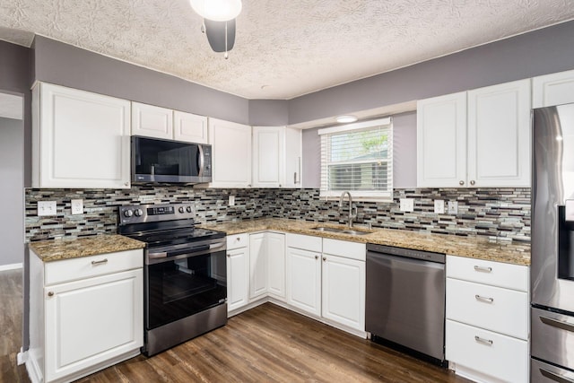 1279 Reana Dr, Galloway, OH 43119 - kitchen with appliances with stainless steel finishes, a sink, dark wood-style floors, decorative backsplash, and a textured ceiling