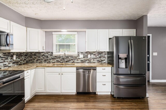 1279 Reana Dr, Galloway, OH 43119 - kitchen with appliances with stainless steel finishes, a sink, decorative backsplash, white cabinets, and a textured ceiling