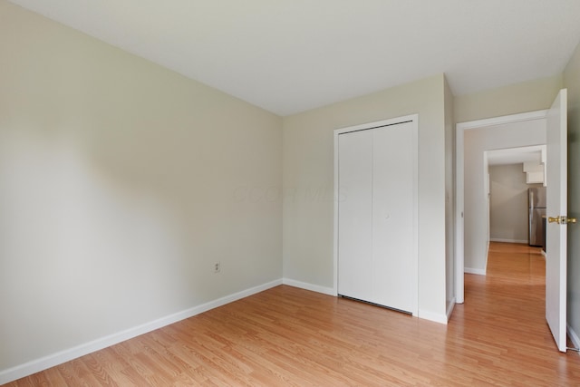 4726 Wendler Blvd, Columbus, OH 43230 - unfurnished bedroom with freestanding refrigerator, light wood-style flooring, baseboards, and a closet