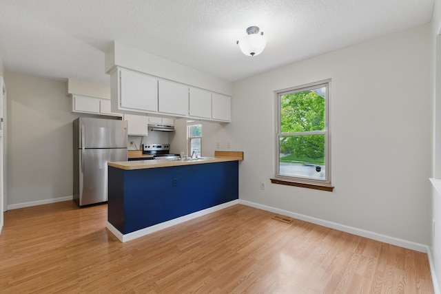 4726 Wendler Blvd, Columbus, OH 43230 - kitchen featuring stainless steel appliances, a peninsula, light wood finished floors, white cabinets, and light countertops