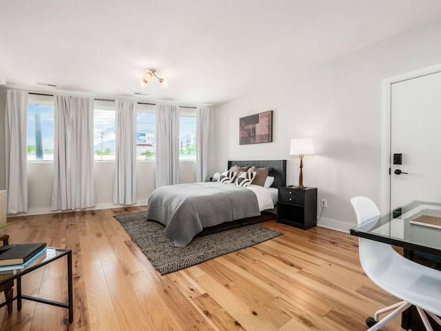 201 E 5th Ave, Columbus, OH 43201 - bedroom with light wood finished floors, multiple windows, and baseboards