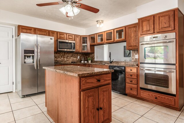 717 Birmingham Rd, Westerville, OH 43081 - kitchen with black appliances, a center island, backsplash, brown cabinets, and a textured ceiling