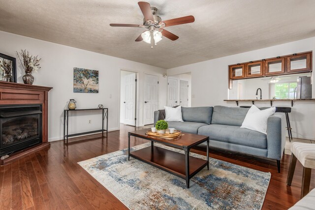 717 Birmingham Rd, Westerville, OH 43081 - living room featuring a ceiling fan, a textured ceiling, dark wood-style flooring, and a glass covered fireplace