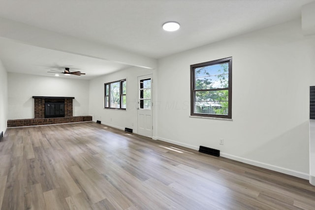 1883 Fairhaven Rd, Columbus, OH 43229 - unfurnished living room with a brick fireplace, wood finished floors, baseboards, and a ceiling fan
