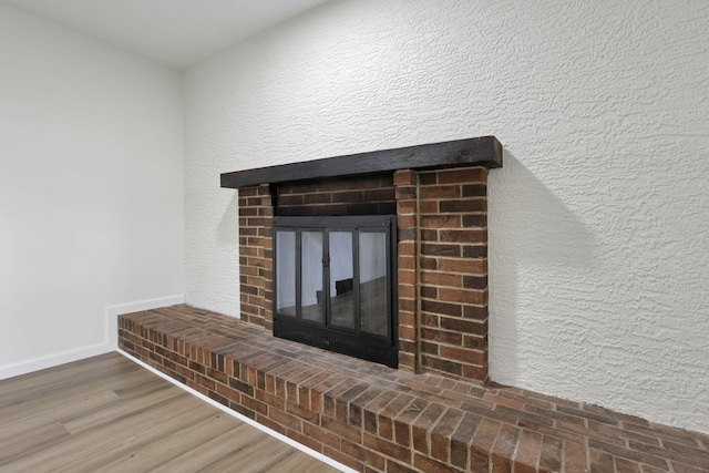 1883 Fairhaven Rd, Columbus, OH 43229 - detailed view of a fireplace, baseboards, wood finished floors, and a textured wall