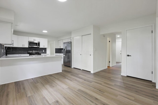 1883 Fairhaven Rd, Columbus, OH 43229 - kitchen with stainless steel appliances, a sink, backsplash, a peninsula, and light countertops