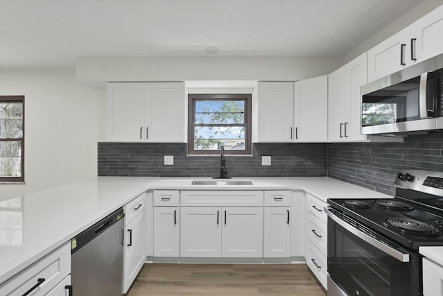 1883 Fairhaven Rd, Columbus, OH 43229 - kitchen with stainless steel appliances, a sink, light wood-style flooring, light countertops, and white cabinetry