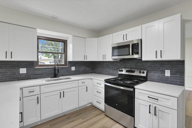 1883 Fairhaven Rd, Columbus, OH 43229 - kitchen featuring stainless steel appliances, a sink, light wood-style floors, and white cabinetry